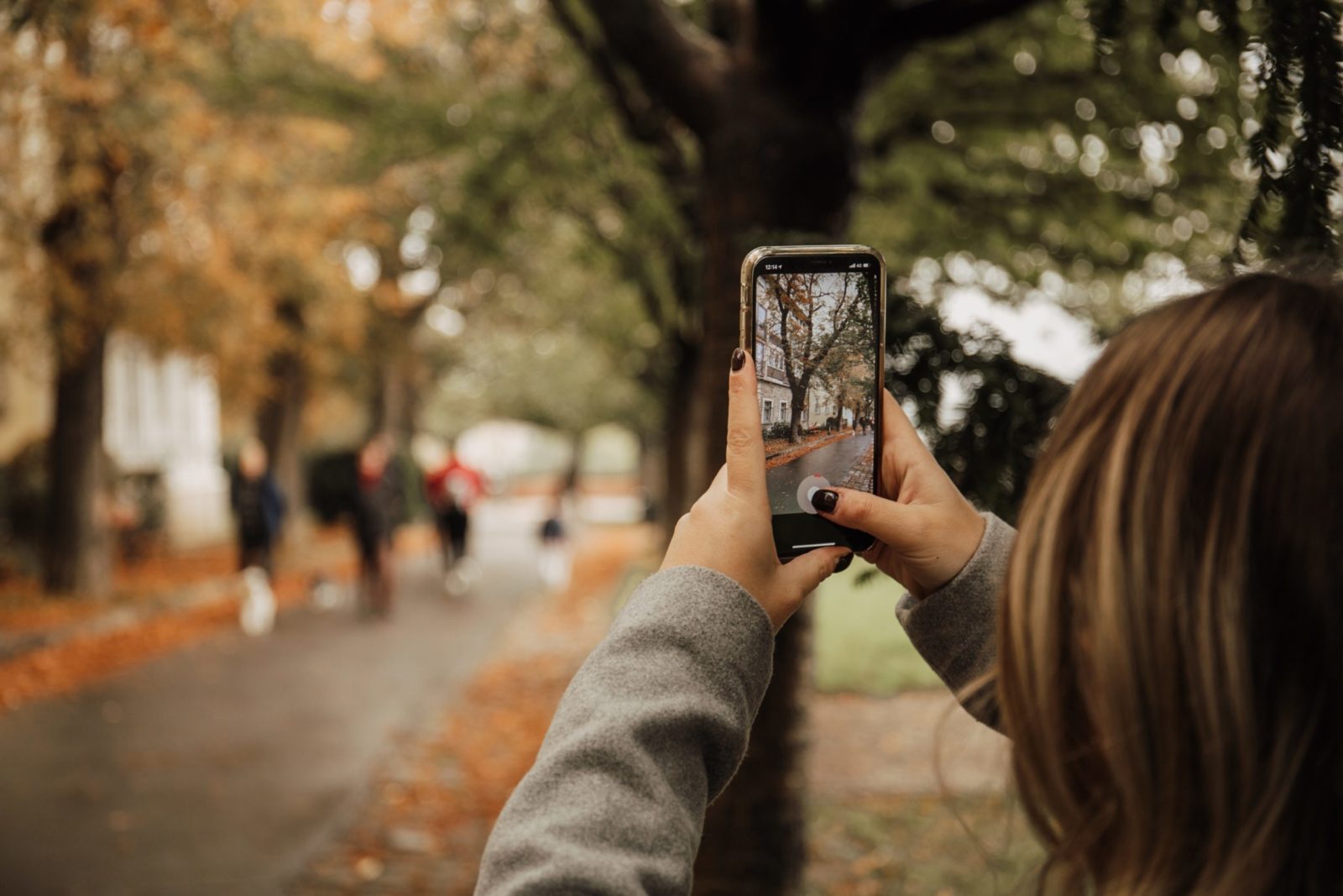 Take photos перевод. Женщина фотографирует на смартфон. Айфон в руке на улице зима. Мальчик на смартфон фотографирует женщину. Упрощение в фотографии.